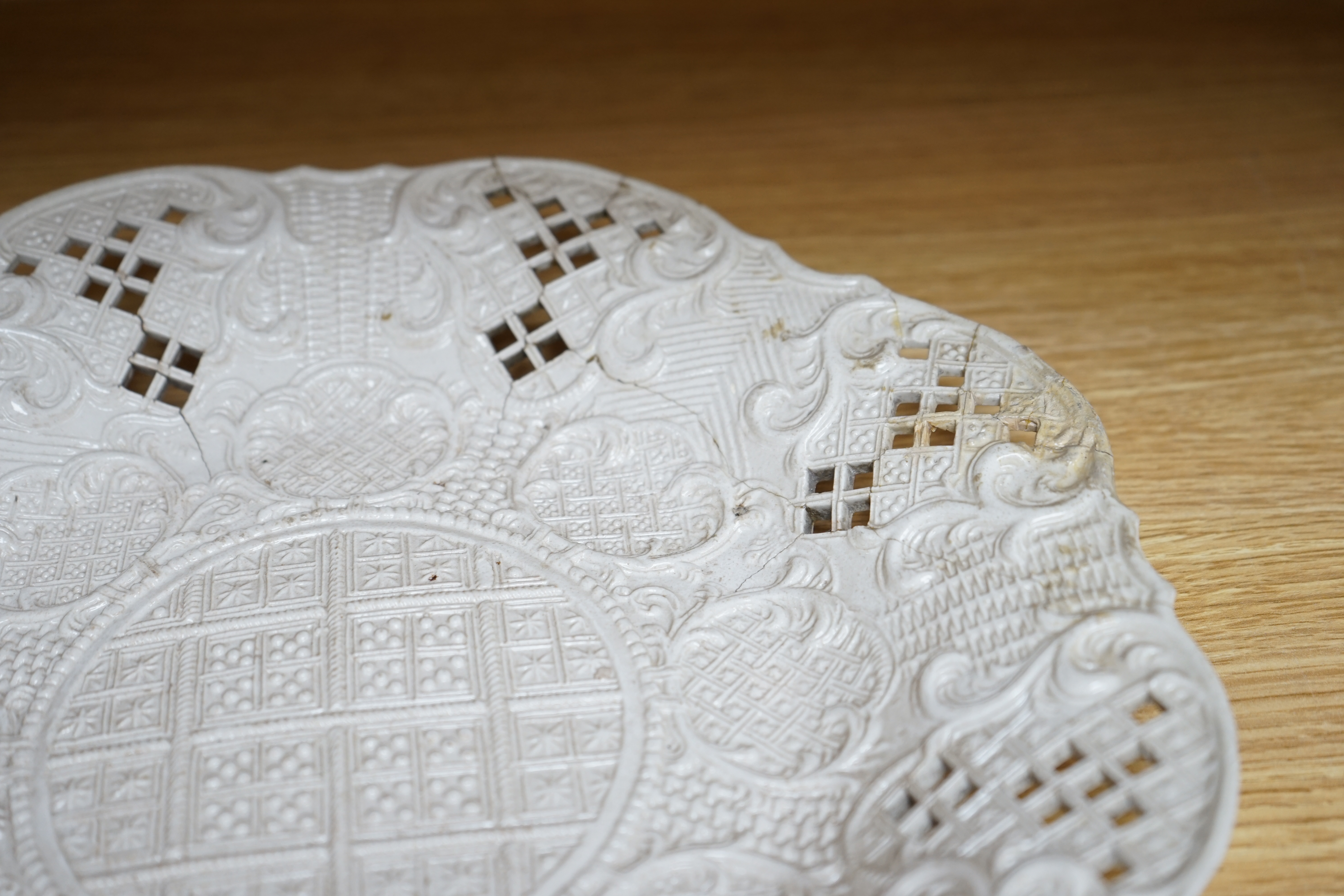 An 18th century white salt-glaze dish, diameter 31cm. (a.f.). Condition - poor, significant cracks and repair